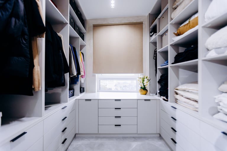 A spacious walk-in closet filled with clothing and bright natural light.